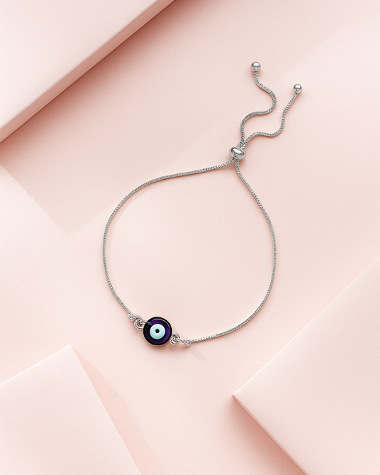 Delicate bracelet with a black bead on a pink fabric background